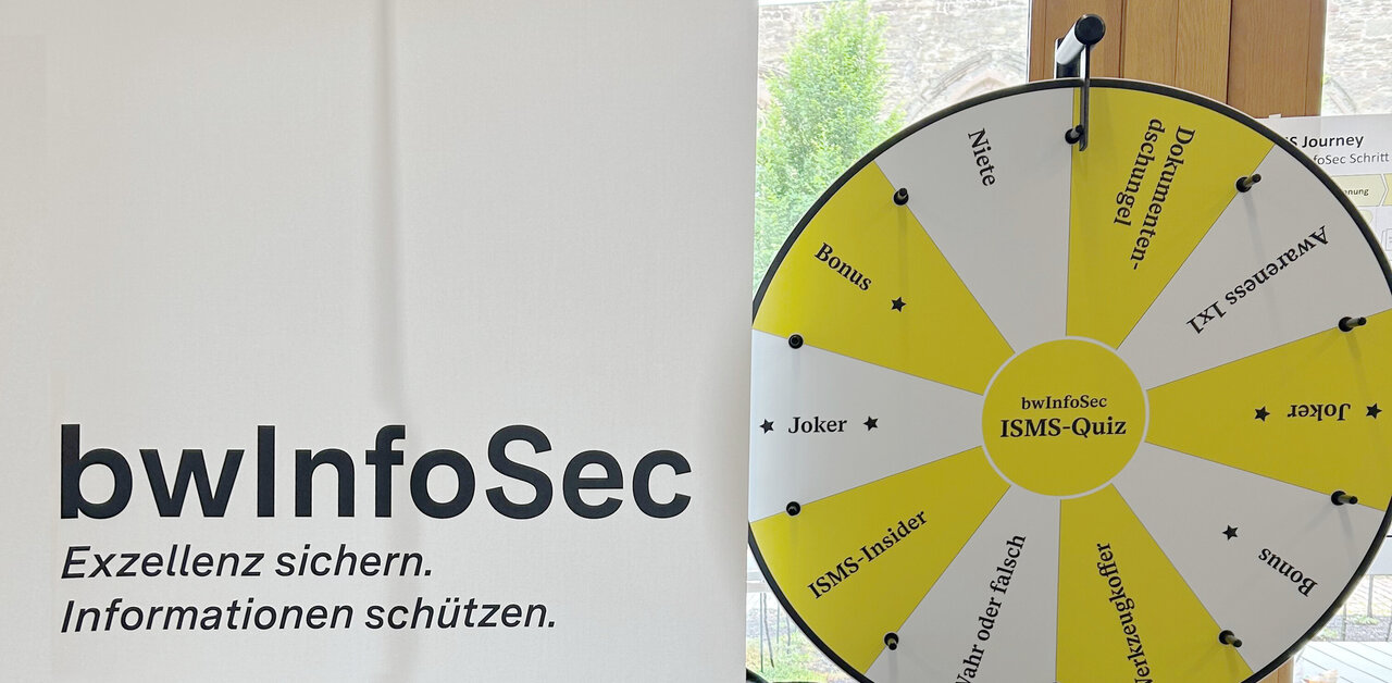 Ausschnitt eines Werbeaufstellers von bwInfoSec, im Hintergrund ein Glücksrad.